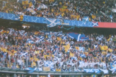 Scotland supporters in dark blue and tartan inside a football crowd