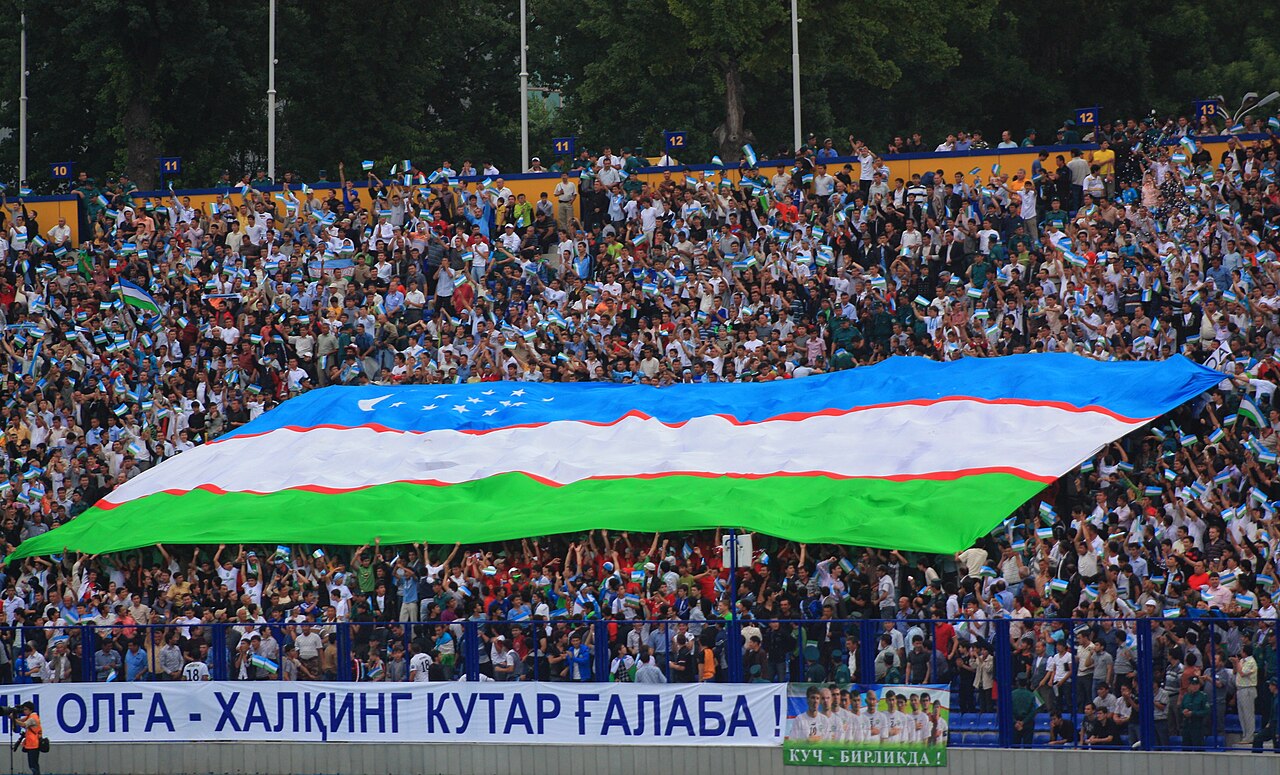 Uzbekistan supporters carrying a large national flag before an international football match